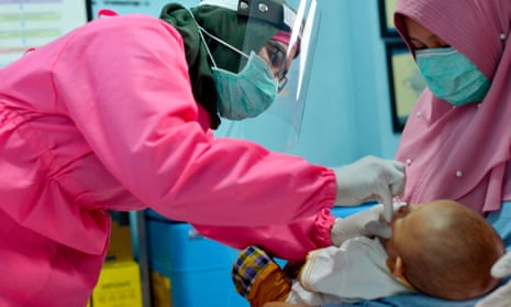A medic in Banda Aceh, Indonesia, gives polio and rubella vaccines to a baby in May 2020.