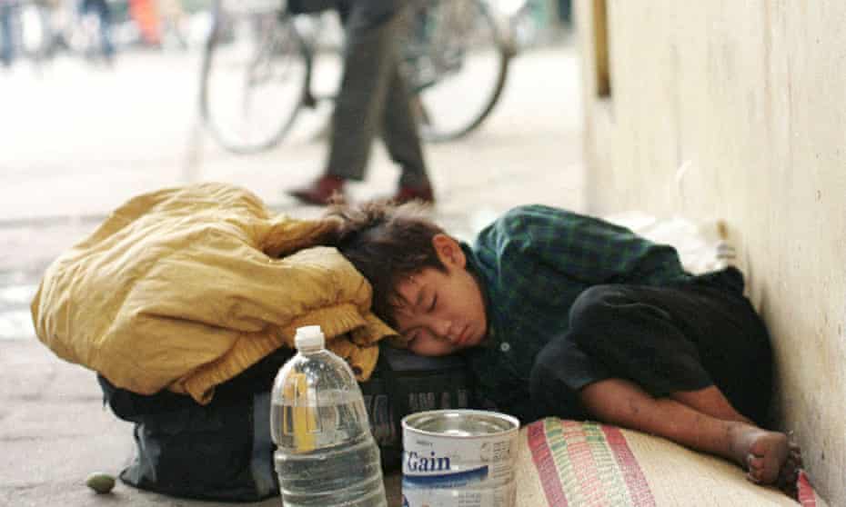 A young homeless child sleeps on the streets of Hanoi