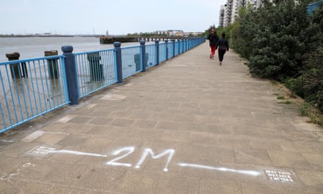 People exercising and maintaining physical distance on Thames Walk, Erith, Kent.