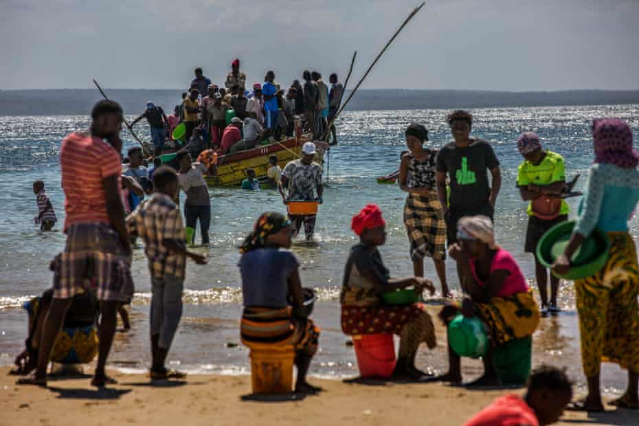 Displaced people board a boat to escape fighting in Cabo Delgado province