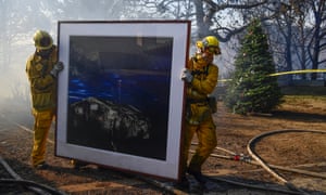 Firefighters remove a painting and Chirstmas tree from a house in Bel-Air on Wednesday.