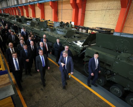line of military vehicles and men in suits