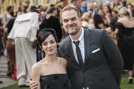 A man and a woman smile on a red carpet