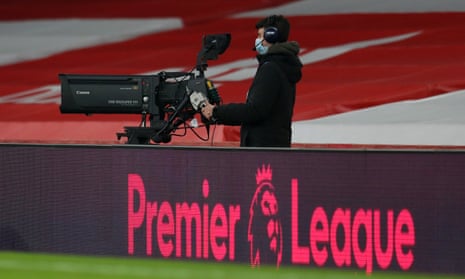 A television camera operator behind the Premier League logo