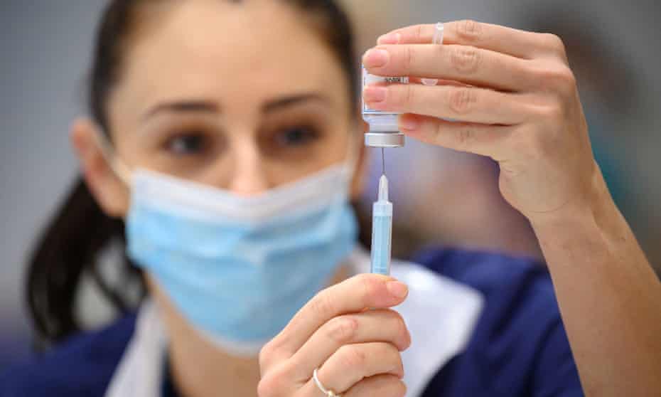 Medical professional preparing shots of Covid-19 vaccine.