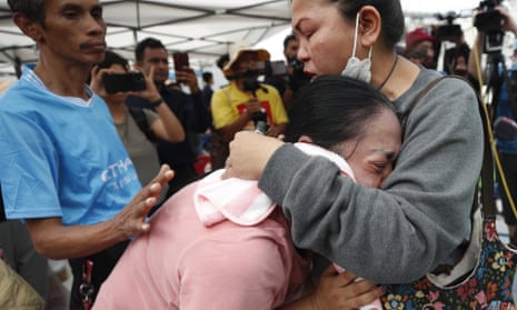 Naruemol Thomglek weeps as she waits for missing family members in Bangkok, Thailand.
