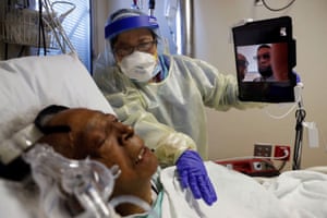 A nurse helps a Covid-19 patient to FaceTime with her family at Roseland Community Hospital in Chicago, Illinois on 1 December 2020