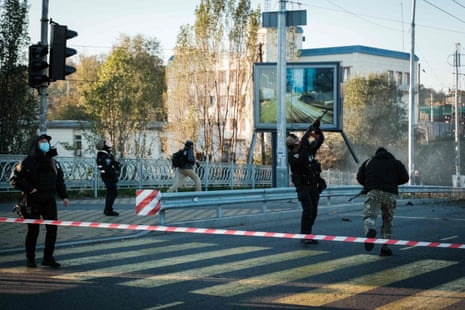 A police officer fires at a drone following attacks in Kyiv.