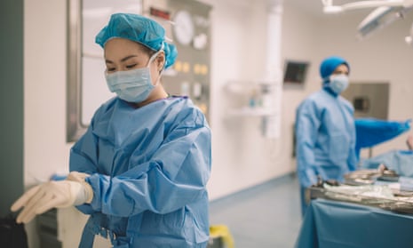 female surgeon doctor is wearing surgical gloves before the surgery in operating room