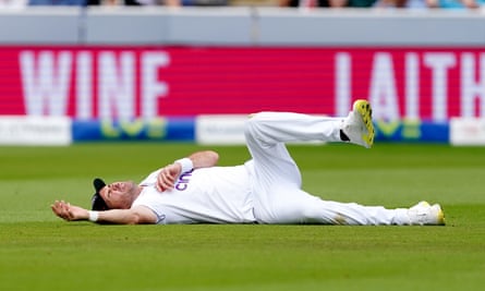 Jimmy Anderson dari Inggris tergeletak di tanah setelah menjatuhkan tangkapan.