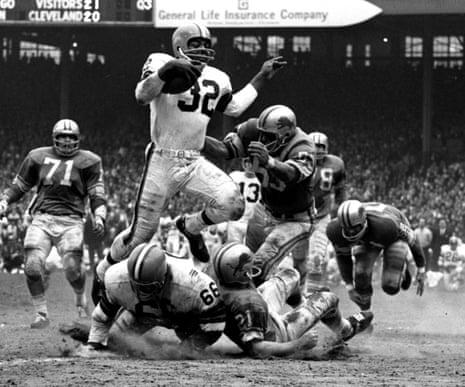 Jim Brown, No 32 of the Cleveland Browns, runs through the defence during a 1964 game against the Detroit Lions at Cleveland Municipal Stadium. 
