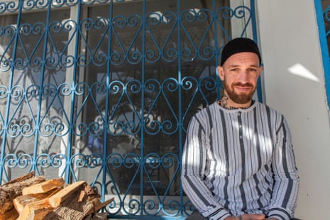 a man sits outside his home