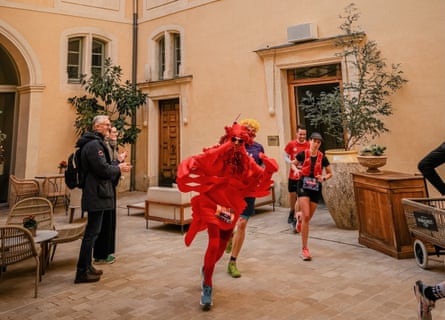 People in fancy dress run through a courtyard