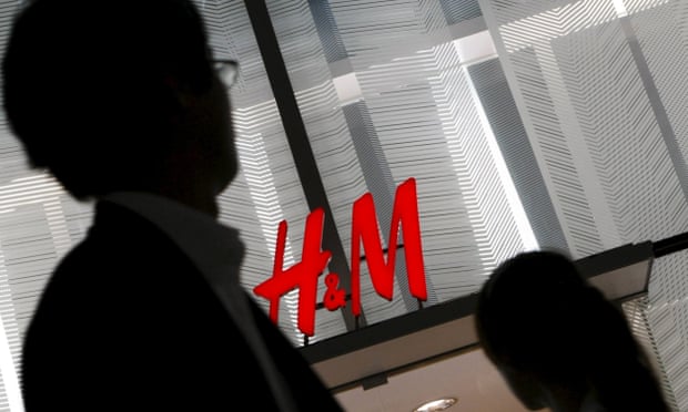 A man walks past an H&M sign