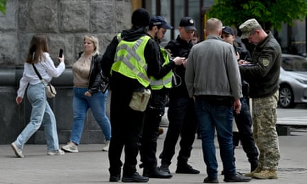 Ukrainian serviceman and police officers check man’s documents