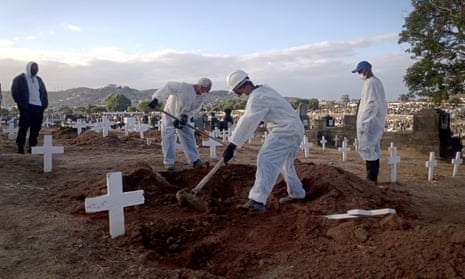 Funeral workers carry out burials of Covid victims at Inhaúma cemetery in Rio de Janeiro