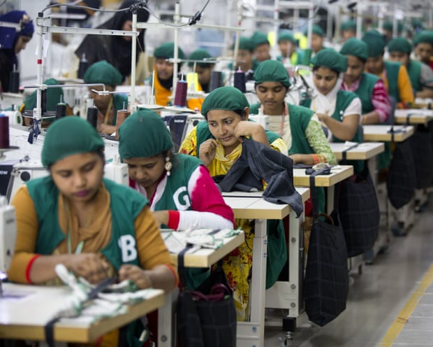 People sitting at benches in a garment factory