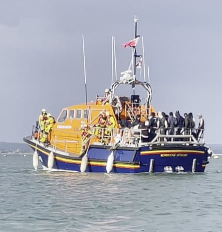 An RNLI lifeboat at sea with a crowd of people on the back of it