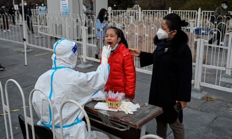 A health worker takes a swab sample from a girl to be tested for Covid at a collection station in Beijing.