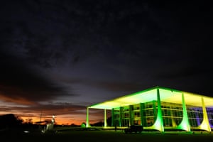 A large, modern court building with dramatic lighting at dawn