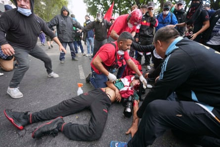 Medics tend to a photographer injured during clashes as police confronted demonstrators in Buenos Aires.