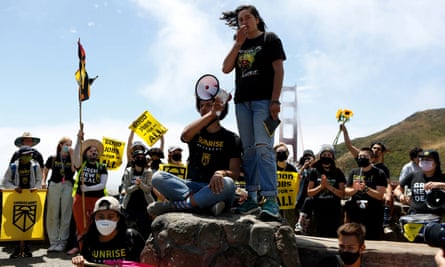Group of young people with yellow and black sings with Golden Gate Bridge in background.