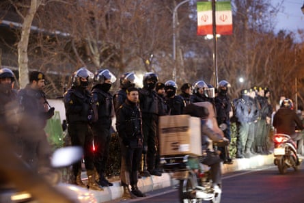 Iranian police officers stand guard at a protest