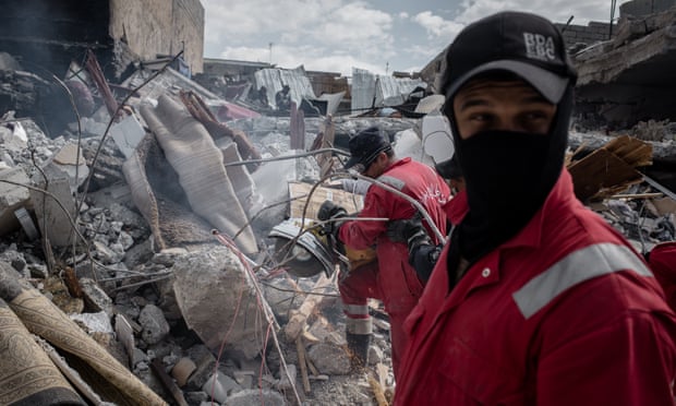 An Iraqi rescue team searches for bodies in the rubble