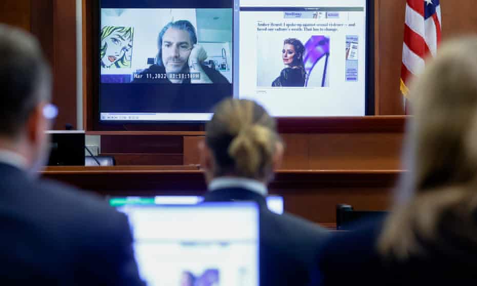 Johnny Depp watches a pre-recorded deposition testimony of Christian Carino during the Depp v Heard defamation trial at the Fairfax County Circuit Courthouse in Fairfax, Virginia, 27 April 2022. 