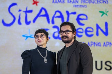 Aamir Khan stands next to Gunjan Soni, left, on stage