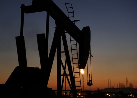 An oil pump works at sunset, in the desert oil fields of Sakhir, Bahrain
