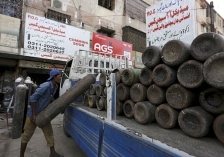 A lorry is loaded with oxygen cylinders to supply private hospitals in Karachi