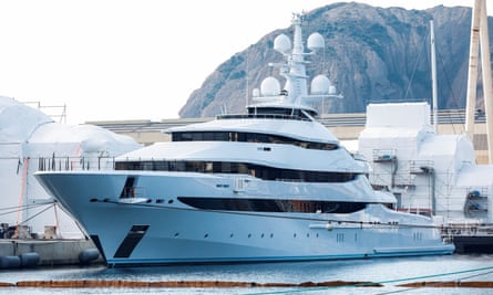 Futuristic white superyacht with several decks tied up at a quayside