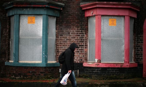 boarded-up houses in Liverpool with man walking past