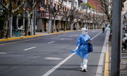 A worker in a protective suit walks down the street in shanghai