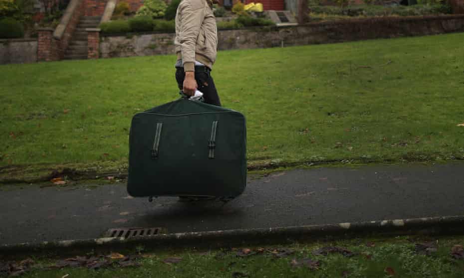 A Syrian refugee carries his luggage to his new home in Rothesay on Bute.