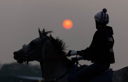 An exercise jockey and horse train at sunrise during a morning workout Wednesday before Saturday's 155th running of the Belmont Stakes at Belmont Park in Elmont, New York. 