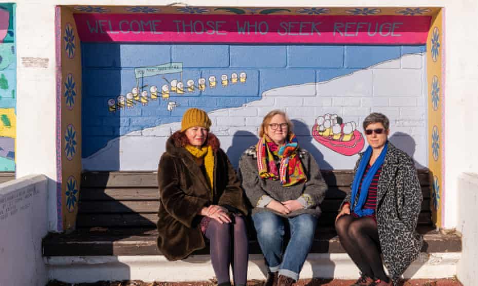 Rachel Lowden, Jane Grimshaw and Rachael Roser photographed in front of artwork by Sarah Gomes, Harris &amp; Helen Dodaki assisted by Lily Dodaki, Nareen Dodaki and Hassan Kafaya of the Refugee Buddy Project.