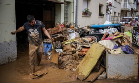 A man clears out mud after the flood