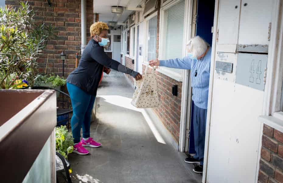 Latoya Stephens delivers the weekly shop to Betty Johnson, 92, a retired nurse.