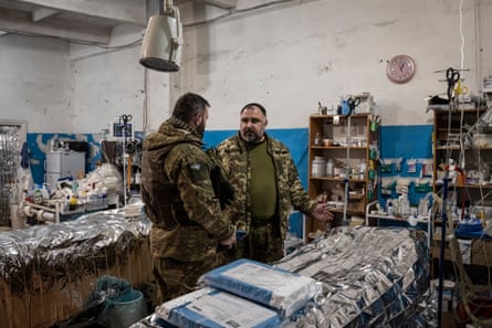 A soldier (left) talks to medical staff in a stabilisation centre in a village close to the frontline.