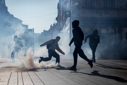 Student protesters run through tear gas smoke during clashes with police in Nancy