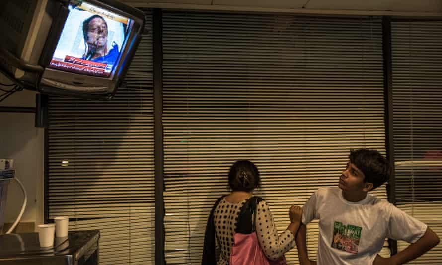 People watch a 2013 television interview with Imran Khan in intensive care after he sustained an injury falling.