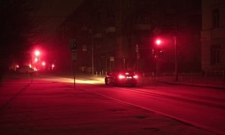 A car drives as red lights glow and snow covers Kyiv’s city centre last week