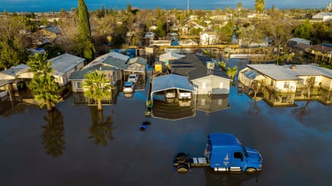 Flood waters surround homes and vehicles in Planada, California, earlier this year.