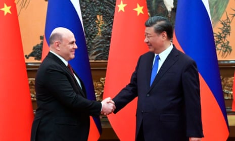 The Russian PM, Mikhail Mishustin, left, and Chinese President Xi Jinping shake hands prior to their talks in Beijing, China, on Wednesday 24 May.