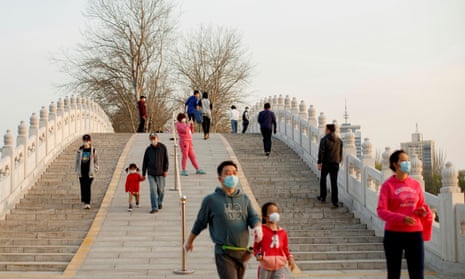 People walk in a park in Beijing