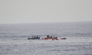 In this photo taken in the Mediterranean Sea, off the Libyan coast, Friday, May 27, 2016, rescuers help migrants to board rubber dinghies before towing them to the Vega.