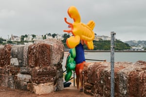 A man carries his children’s inflatable lilos from the beach in Torquay