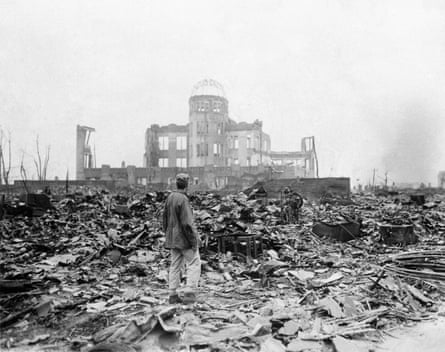 An allied correspondent stands in the rubble in front of the shell of a building that once was a exhibition center and government office in Hiroshima, Japan, a month after the first atomic bomb.